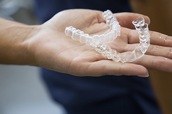 Zwei Invisalign Schienen liegen auf Handfl&auml;che