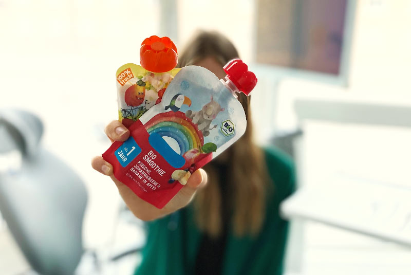 Frau hält zwei Quetschies in die Kamera